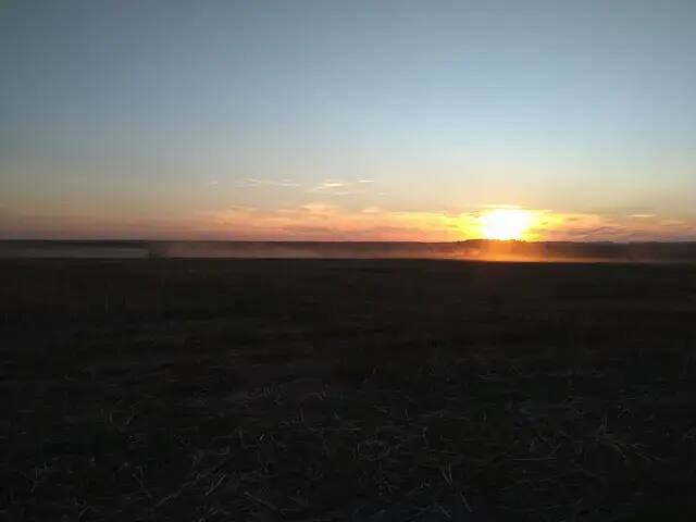 Harvest stubble at dusk Stubble after harvest at sunset with a combine in the distance